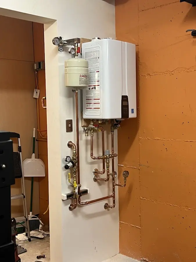 Plumbing technician inspecting water heater connections in Ocean Shores